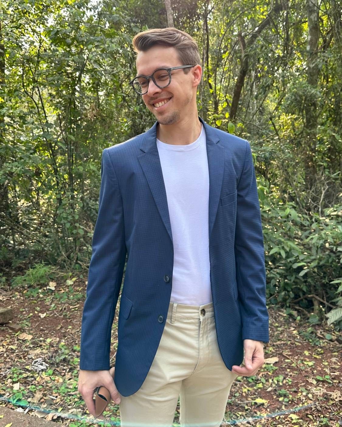 Federico Gunther, sonriendo, con saco azul y remera blanca, en la selva misionera.